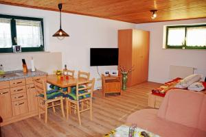 ein Wohnzimmer mit Tisch und eine Küche mit Couch in der Unterkunft Ferienwohnung Zudar auf Rügen in Zudar