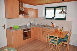 eine Küche mit Holzschränken und einem Holztisch mit Stühlen in der Unterkunft Ferienwohnung Zudar auf Rügen in Zudar + 18 Fotos