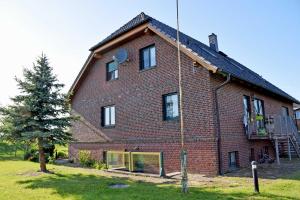 ein großes Backsteinhaus mit einem Baum davor in der Unterkunft Ferienwohnung Zudar auf Rügen in Zudar