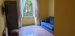 ein Wohnzimmer mit einem blauen Sofa und einem Fenster in der Unterkunft La Breccia A Porta Pia in Rom