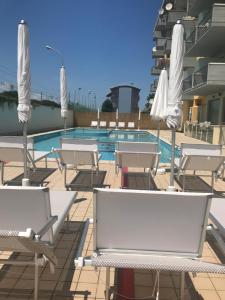 a row of chairs sitting on top of a beach at Hotel Royal in San Benedetto del Tronto