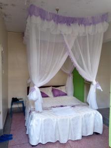 a bedroom with a canopy bed with purple pillows at Nanyuki Ibis Hotel in Nanyuki