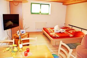 ein kleines Zimmer mit einem Bett und einem Tisch mit einer Flasche Wein in der Unterkunft Ferienwohnung Zudar auf Rügen in Zudar