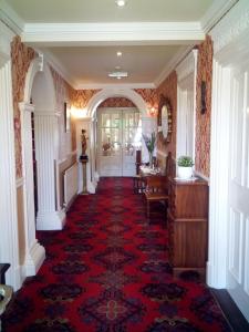 a hallway with a red carpeted floor and a door at Rosemount B&B in Dundalk