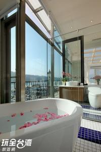 een grote badkamer met een bad met bloemen erin bij Shuian Lakeside Hotel in Yuchi