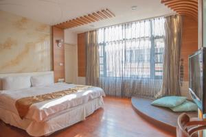 a bedroom with a bed and a large window at Shuian Lakeside Hotel in Yuchi