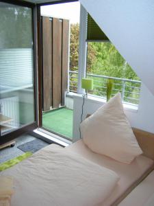 Cama con almohada en habitación con ventana en Wietheger's Ferienwohnungen, en Willingen