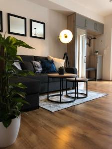 a living room with a black couch and a table at Apartmány Koněvova in Mikulov