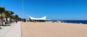uma grande tenda branca numa praia junto ao oceano em Apartamento a 100 metros de la playa em Pineda de Mar