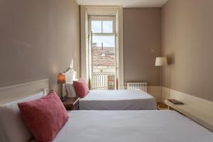 a hotel room with a bed and a window at Being Porto Hostel in Porto