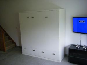 einen weißen Schrank mit einem TV an der Wand in der Unterkunft Wietheger's Ferienwohnungen in Willingen