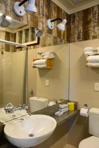 un bagno con lavandino, WC e specchio di Apartamento Kami a Porto Alegre Altre 54 foto