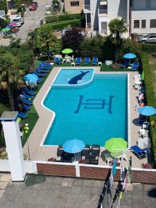 einen Blick über einen Pool mit Sonnenschirmen in der Unterkunft Hotel Centrale in Eraclea Mare