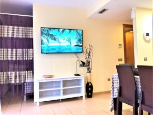 a living room with a flat screen tv on a wall at Lloret Beach Apartments in Lloret de Mar