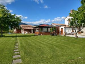 un patio con una casa y un campo de hierba en Agriturismo Il Cavallino Saturnia, en Semproniano