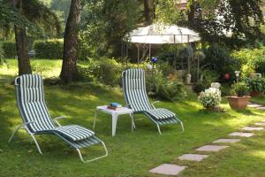 巴特歐波的住宿－萊茵蘭酒店，草地上两把椅子和一张桌子,上面有雨伞
