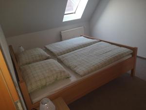 two beds in a small bedroom with a window at Ferienwohnung Almdorf in Almdorf