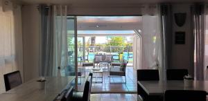 a dining room with a table and chairs and a patio at Hôtel Althea - Piscine et Sauna in Béziers