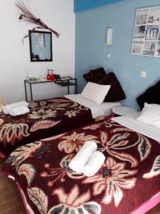 two beds sitting next to each other in a room at Sol e Mar Sea Side View Guesthouse in Perama