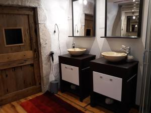 two sinks in a bathroom with two mirrors and a door at Le Paillier d'Etienne. in La Cresse +44 photos