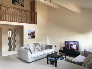 a living room with a couch and a tv at Westwood Barn Holiday Let in Brough Sowerby