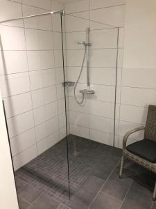 eine Dusche mit einer Glastür und einem Stuhl in der Unterkunft Modernes Apartment in ruhiger Lage, 70qm, 4 Personen in Brietlingen + 7 Fotos