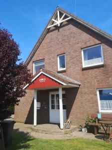 a brick house with a red awning on it at Ferienwohnung Almdorf in Almdorf