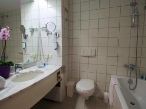 a bathroom with a sink, toilet and bathtub at Arion Cityhotel Vienna und Appartements in Vienna