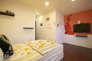 1 dormitorio con 1 cama y TV de pantalla plana en Lanyu Shundouchi Homestay, en Lanyu