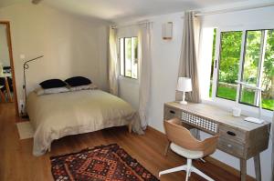 1 dormitorio con cama, escritorio y silla en Charmante maisonnette indépendante à Goult en Luberon, en Goult
