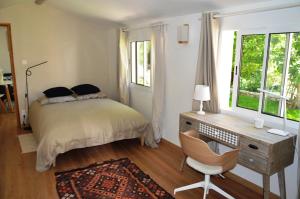 a bedroom with a bed and a desk and a chair at Charmante maisonnette indépendante à Goult en Luberon in Goult