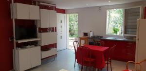 a kitchen with a table with a red table cloth at Clos l'Oustal in Labastide-de-Virac