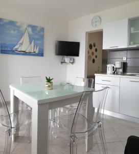 eine Küche mit einem Tisch mit Stühlen und einem Segelboot an der Wand in der Unterkunft Apartments ONE PALM in Podstrana