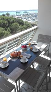 una mesa con platos de comida en la parte superior de un balcón en Grand studio climatisé en bord de mer avec parking sécurisé, en Golfe-Juan