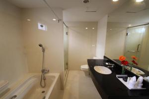a bathroom with a sink and a tub and a toilet at GM Complex Apartment in Bangkok