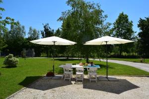 two white tables and chairs under two umbrellas at Casa Vacanza e per lavoro Tessyhouse in Spinea
