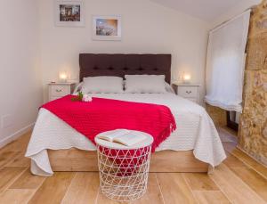 a bedroom with a large bed with a red blanket at Casa Brétema en 1ª línea de playa in Boiro