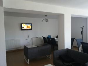 a living room with a couch and a tv on the wall at CASA DRAGON in Sulina