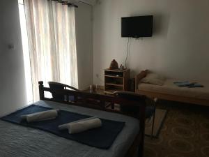 Habitación pequeña con 2 camas y TV. en Miron apart&rooms, en Rafailovici