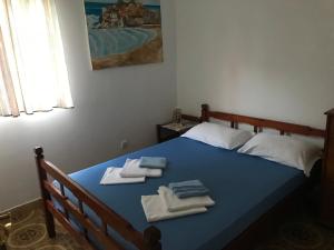 Un dormitorio con una cama azul con toallas. en Miron apart&rooms, en Rafailovici