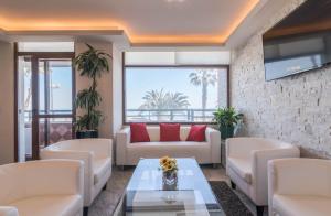 a living room with white couches and a tv at Luxury Premium in Málaga