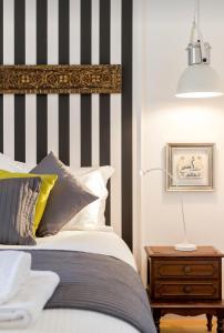 a bed with a black and white striped headboard at Gulbenkian Gardens Apartments in Lisbon