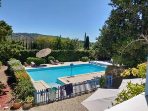 a swimming pool in a yard with a fence at La Luberonne in Lourmarin