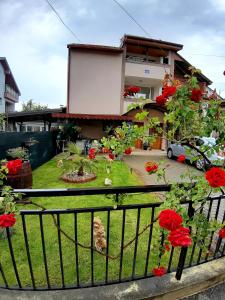 a house with a yard with red flowers at Apartment Jonoski in Ohrid