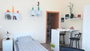 ヘンミンゲンにあるHelles 1-Zimmer-Apartment in Hemmingen/Hannoverのベッドとデスクが備わる小さな客室です。