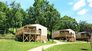 a group of cottages with trees in the background at Camping White Rock in Castellane