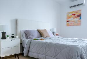 a white bedroom with a bed and a white dresser at Enchanting City View Apartment - PH Quartier Del Mar in Panama City +31 photos