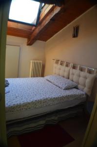 a bedroom with a bed with a white bedspread and a window at Appartamento Mara in Domodossola