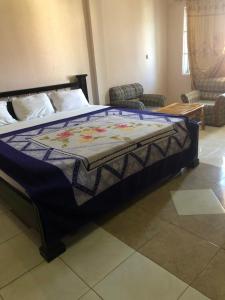 ein Bett mit einer Decke in einem Schlafzimmer in der Unterkunft Pemicsa Hotel Accra in Spintex
