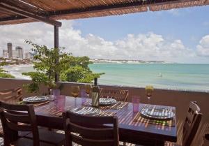 una mesa con copas de vino y vistas al océano en Coco Beach, en Natal